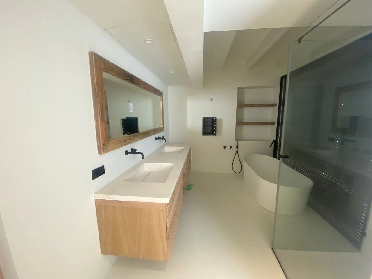 Baño en microcemento con bañera exenta y madera en Ibiza
