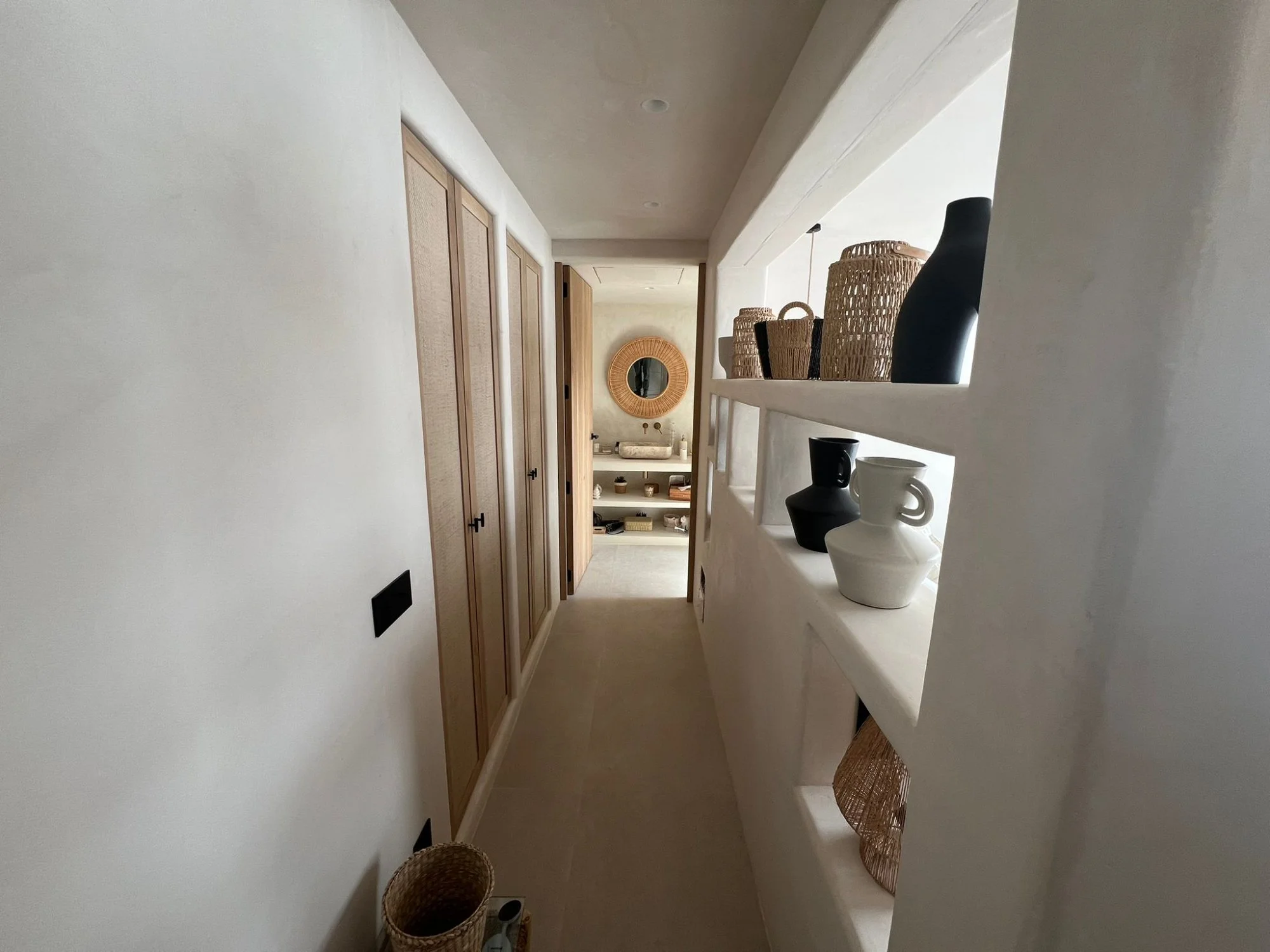 Pasillo con puertas de madera y suite en reforma integral en Ibiza
